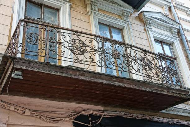 istock one old open iron balcony on a brown wall with windows 1061340950