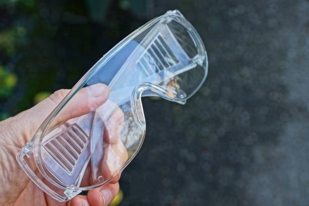 transparent plastic construction glasses in hand on the street