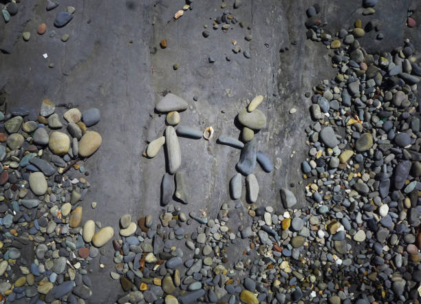 A romantic couple with a church ring made of stones in the sand.