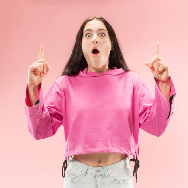 istock Beautiful woman looking suprised isolated on pink 1061346098