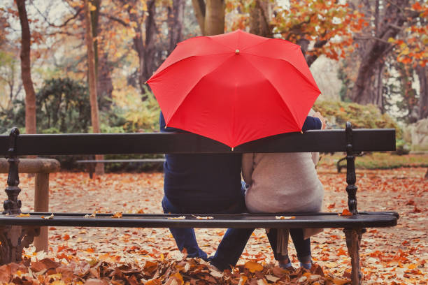 happy elderly couple in love, retired people under umbrella. - forest sitting men comfortable imagens e fotografias de stock