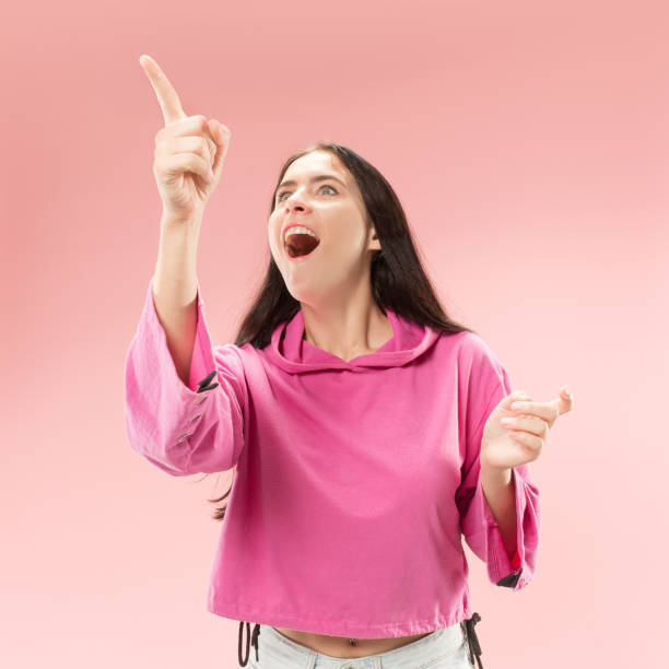 istock Beautiful woman looking suprised isolated on pink 1061353356