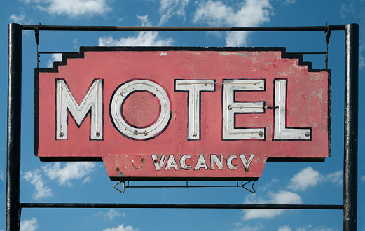A weathered sign invites travelers to stop at a small motel in rural Minnesota.