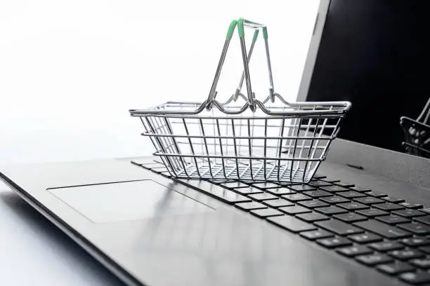 Shopping e-commerce concept. Shopping basket empty "nstanding on laptop keyboard, on white background. Copy space