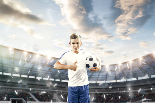 istock Young boy with soccer ball doing flying kick at stadium 1061356198