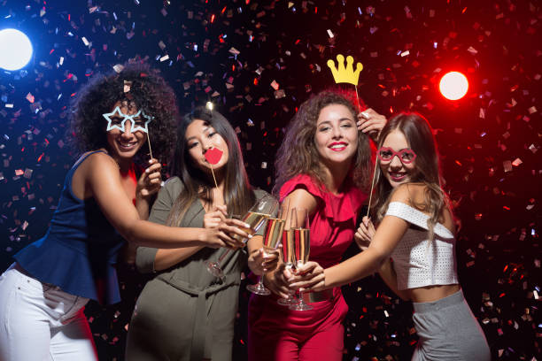 Happy women celebrating New Year at nightclub Fun at New Year party. Happy women celebrating and posing with photo props and champagne new year photos stock pictures, royalty-free photos & images
