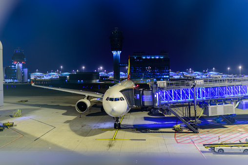 The airplane parked at the aircraft landing at night. Prepare to wait for passengers to travel or send passengers arriving at the airport.