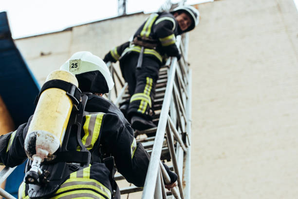 istock selective focus of firefighters in fireproof uniform standing on ladder 1061370080