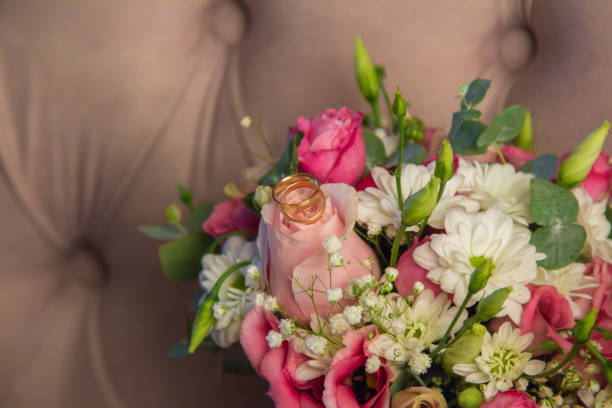 istock Wedding Rings on beautiful natural flowers bouquet 1061374638