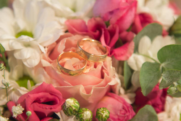istock Wedding Rings on the natural roses bouquet 1061374678