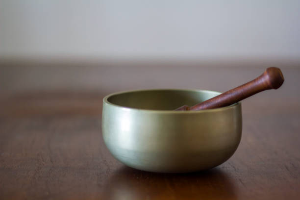 木製のテーブルにチベットの歌ボウル - music wellbeing rin gong bowl ストックフォトと画像