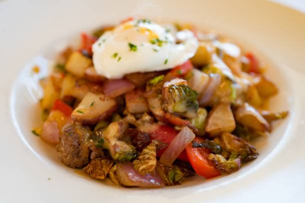 Steak Hash Close-up of a breakfast hash plate with steak, brussels sprouts, vegetables and a poached egg, October 20, 2018. (Photo by Smith Collection/Gado/Getty Images) steak and eggs breakfast stock pictures, royalty-free photos & images
