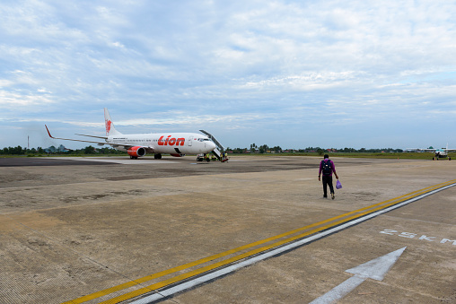 A passenger walks toward a Lion Air Boeing 737-900ER on the airport tarmac in Palangkaraya, Central Kalimantan, Indonesia. (March 13, 2017)