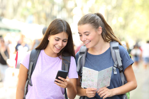 istock Happy backpackers consulting a guide outdoor 1061383712