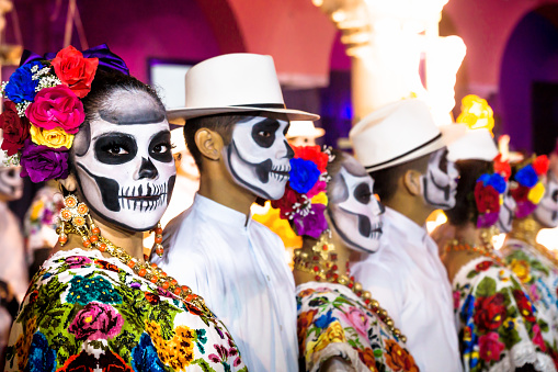 Merida, Mexico - October 29, 2018: Dance performers with  with Catrina skulls makeup for dia de los muertos lining up after the dancing show for photographers in front of Palacio Municipal at Festival de las Animas