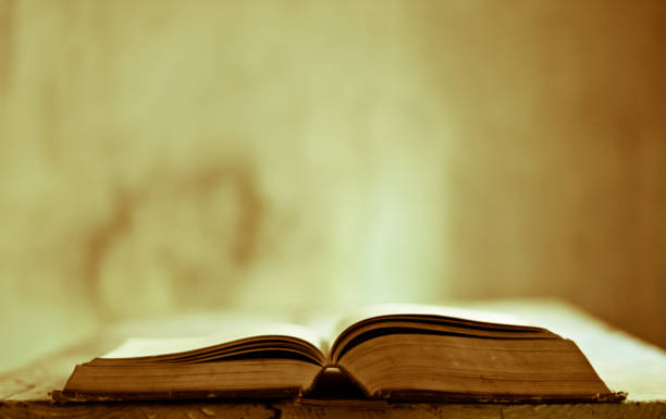 un viejo libro en una mesa antigua en una casa antigua - bible study university old fashioned fotografías e imágenes de stock