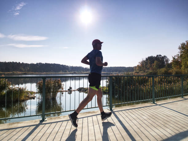 istock Man is training in the nature with sun behind him. Young man 1061389992