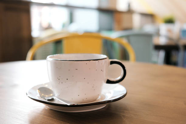 istock Coffee drink on wooden table with blur cafeteria as background. 1061390142