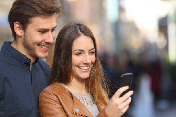 istock Couple checking phone content in an old town street 1061390332