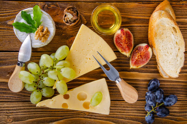 Cheese, fruit and honey. Tool for cheese. Wooden table. View from above. Cheese, fruit and honey. Tool for cheese. Wooden table. Top view. тост stock pictures, royalty-free photos & images