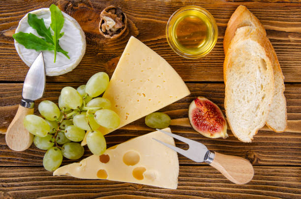 Cheese, fruit and honey. Tool for cheese. Wooden table. View from above. Cheese, fruit and honey. Tool for cheese. Wooden table. Top view. тост stock pictures, royalty-free photos & images