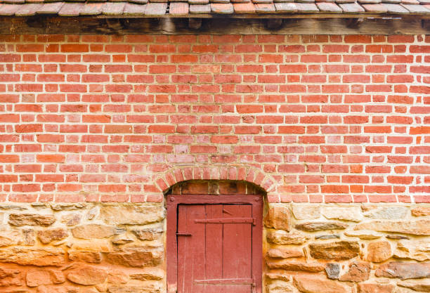 Old Brick Wall and Red Door with stone foundation for background.