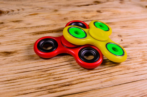 istock Two fidget spinners on wooden desk 1061392580