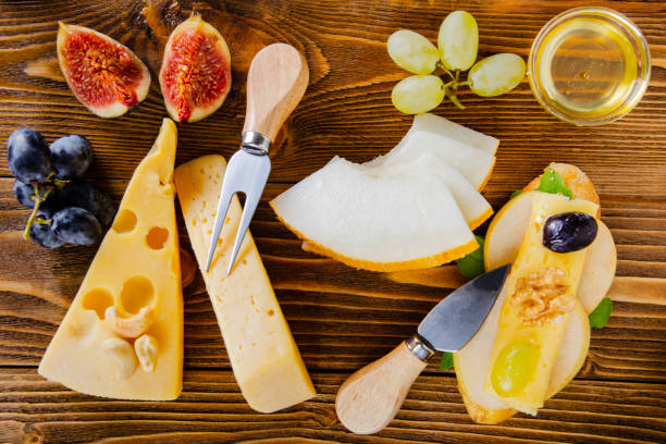 bruschetta with cheese, fruit and nuts is drizzled with honey, on a wooden table. bruschetta with cheese, fruit and nuts is drizzled with honey, on a wooden table. тост stock pictures, royalty-free photos & images