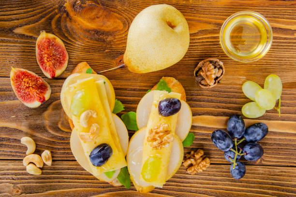 Cheese, fruit and honey. Tool for cheese. Wooden table. View from above. Cheese, fruit and honey. Tool for cheese. Wooden table. Top view. тост stock pictures, royalty-free photos & images