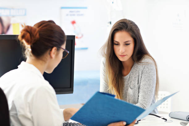Adult woman having a visit at female doctor's office stock photo