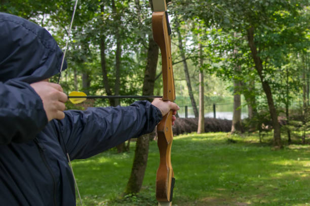 istock the shooter in the blue hood, pulls the bow string, to hit the target 1061402180