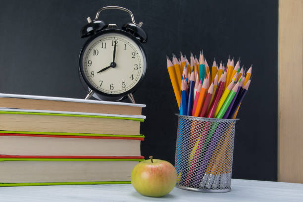 istock on the table a stack of books with an alarm clock on top, a snack break 1061403466