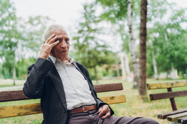 istock Sad senior man sitting on a park bench 1061406102