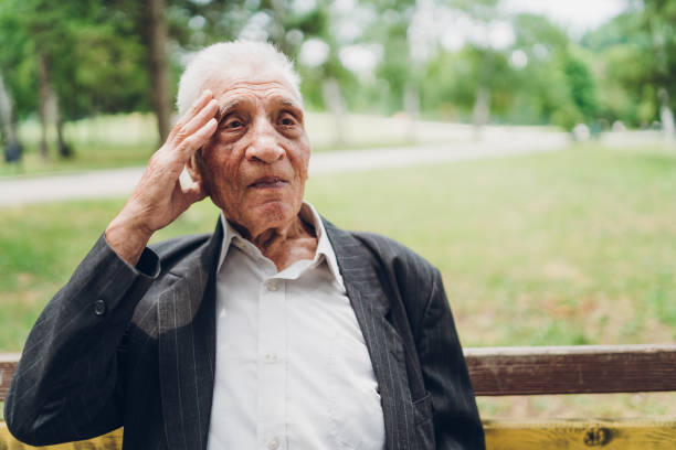 istock Sad senior man sitting on a park bench 1061406250