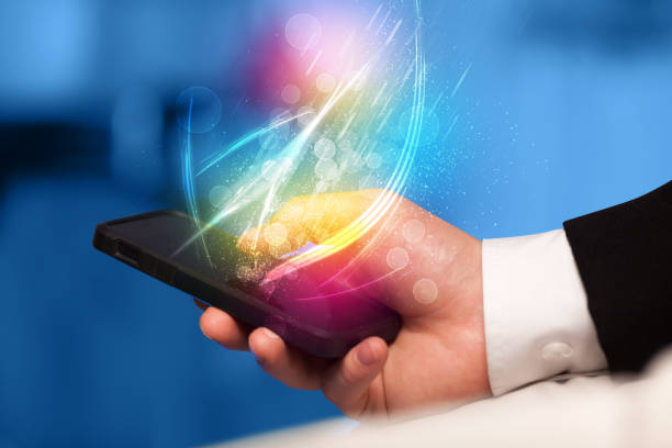 istock Hand holding smart phone with abstract glowing lines 1061406558