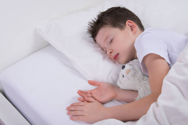 istock the boy is sleeping with his favorite toy, in a white bed 1061406742