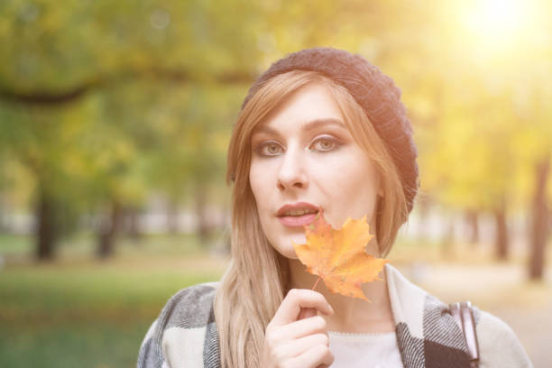 istock Cute smiley woman holding autumn leaves 1061409268
