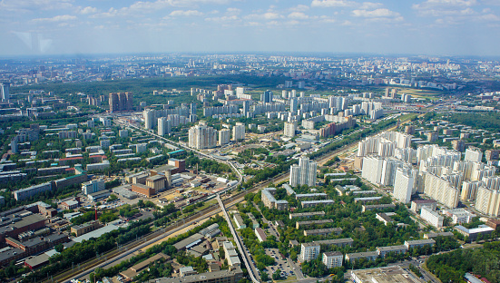 Top view of big city in the summer on sunny day. Urban panorama of cityscape and blue sky. Residential neighborhoods offices and office buildings