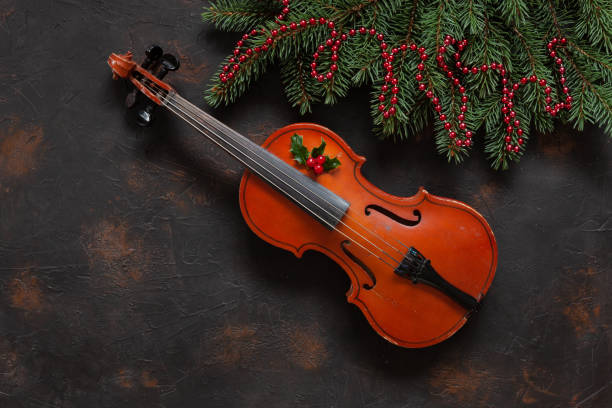 クリスマス装飾が施された古いヴァイオリンとモミの木の枝。クリスマス、新年の概念。上面ビュー、暗いコンクリート背景にクローズ アップ - ragtime ストックフォトと画像