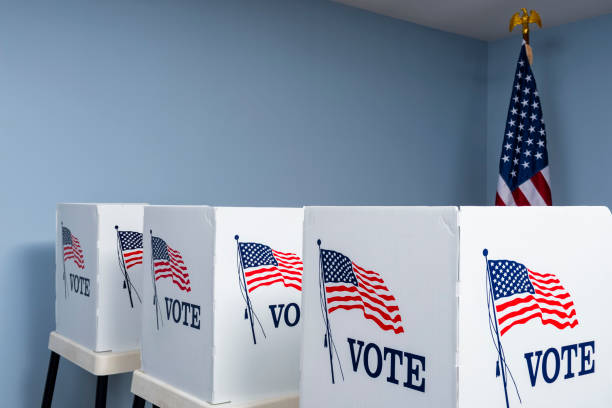 istock Empty voting booths with American flag at polling station 1061419278