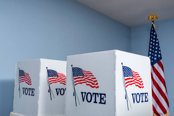 istock Empty voting booths with American flag at polling station 1061419298