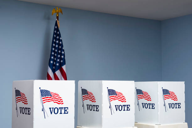 istock Empty voting booths with American flag at polling station 1061419312