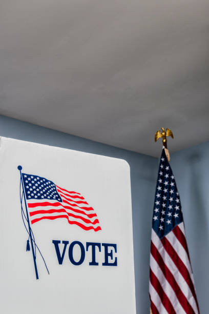 istock Looking up at empty voting booths with American flag at polling station 1061419362