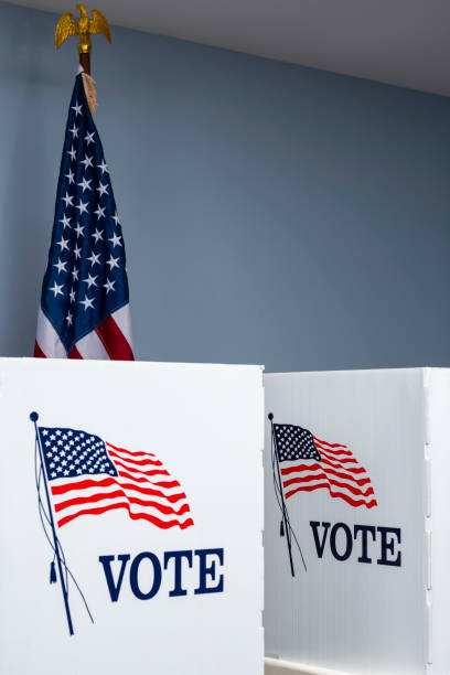 istock Empty voting booths with American flag at polling station 1061419410