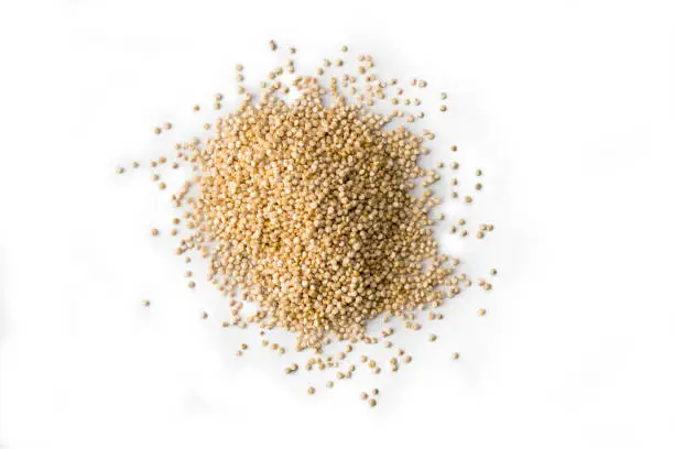 Heap of raw Quinoa seeds on white, high angle view