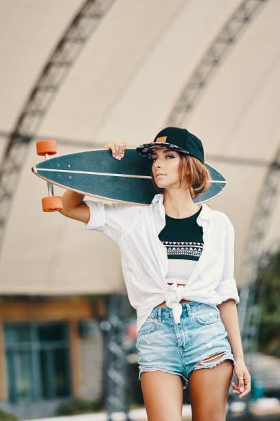 istock Stylish urban girl posing with Longboard 1061429244
