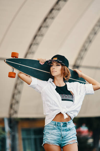 istock Stylish urban girl posing with Longboard 1061429250