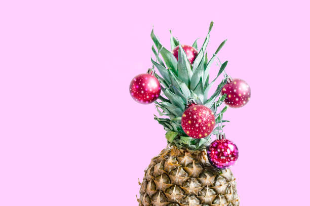 istock pineapple with red Christmas decorations on a pink background 1061430004