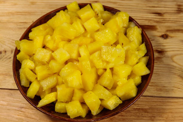 istock Diced pineapple in a plate on wooden table. Top view 1061434656