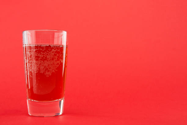 rojo líquido (agua) en un vaso sobre un fondo escarlata con espacio de copia - 6721 fotografías e imágenes de stock